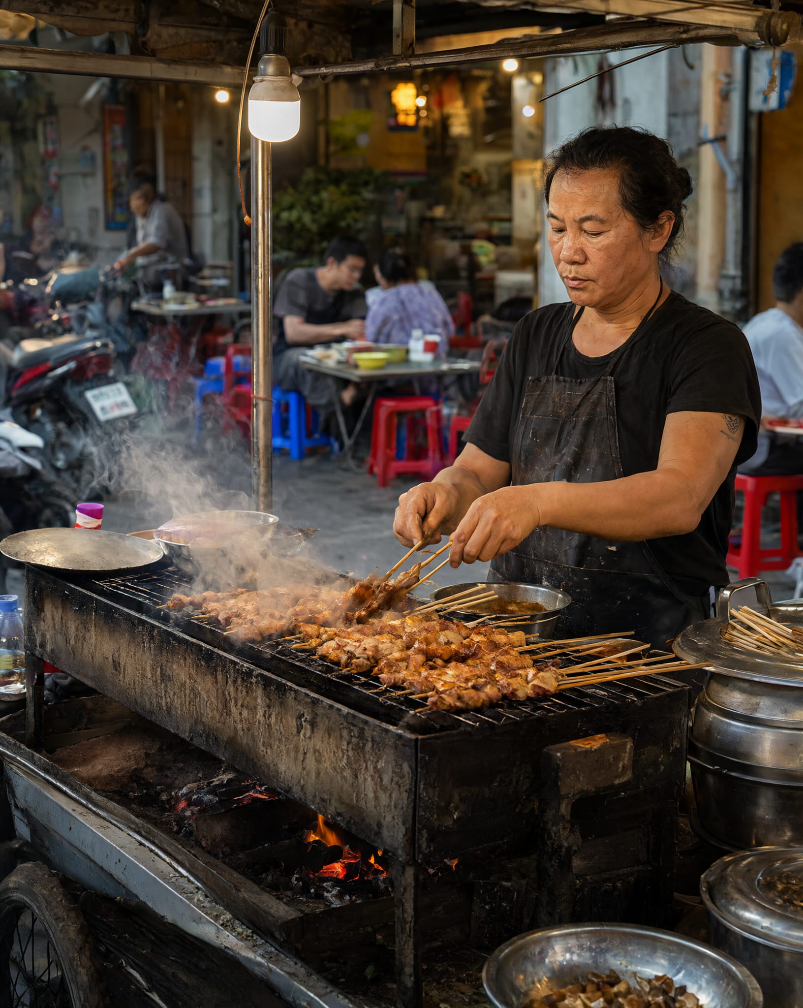 Grilling skewers at a street-food stall in Hanoi
